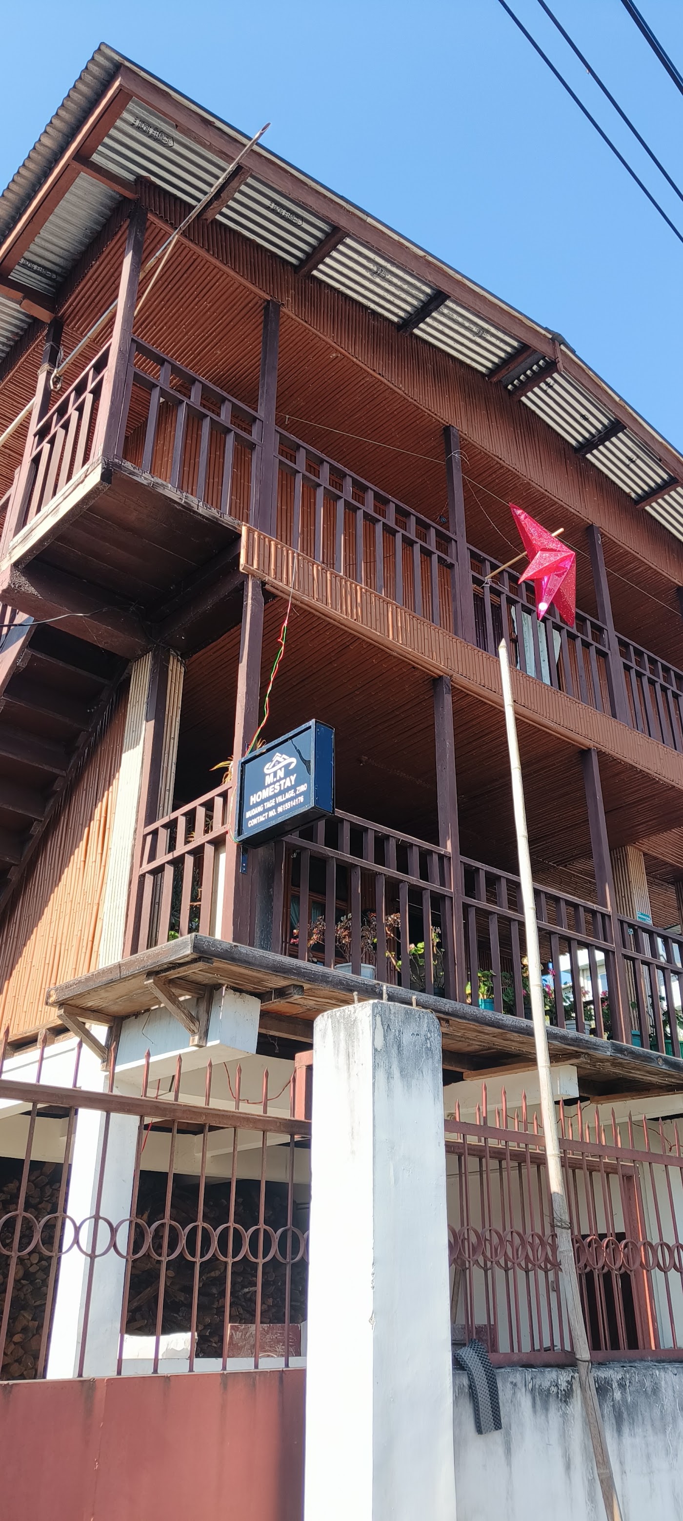 The full front of M.N Homestay, two balconies and a corrugated roof