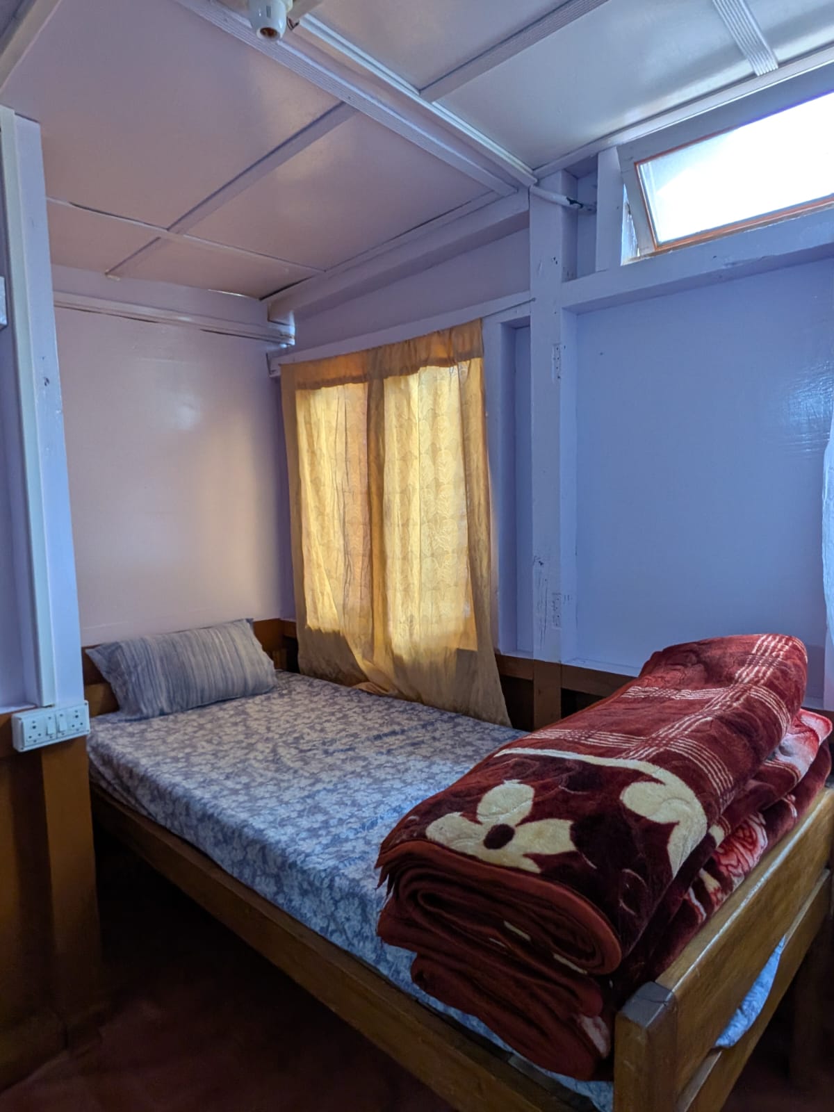 The single bed in an alcove in Room 4, with a skylight above